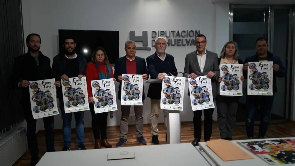 El alcalde de Manzanilla junto con el presidente de la Diputaci&oacute;n de Huelva presentan el cartel de la feria del vino y el aceite acompa&ntilde;ados por miembros de la junta de la Hdad y otros concejales del Ayto.
