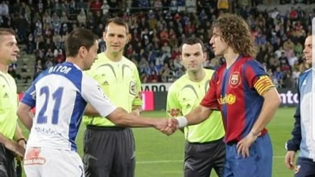 Aitor Tornavaca se saluda con Carles Puyol en un encuentro en el Colombino. de la temporada 2007-08, que termin&oacute; con empate a dos