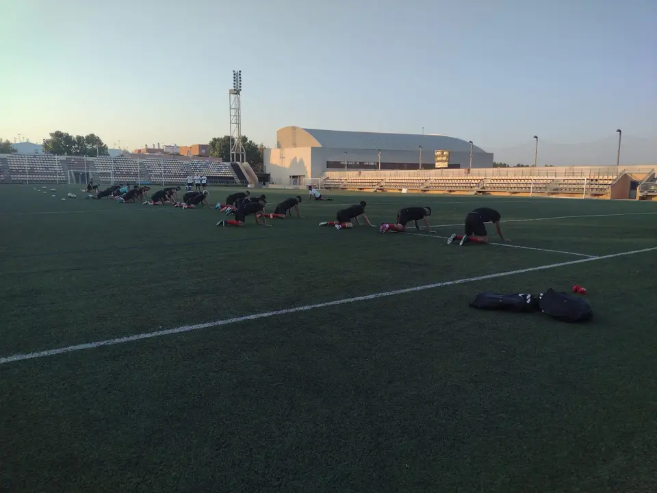 Los jugadores del conjunto ayamontino realizan ejercicios de estiramiento durante las primeras sesiones de la temporada. Fuente: Twitter Ayamonte CF