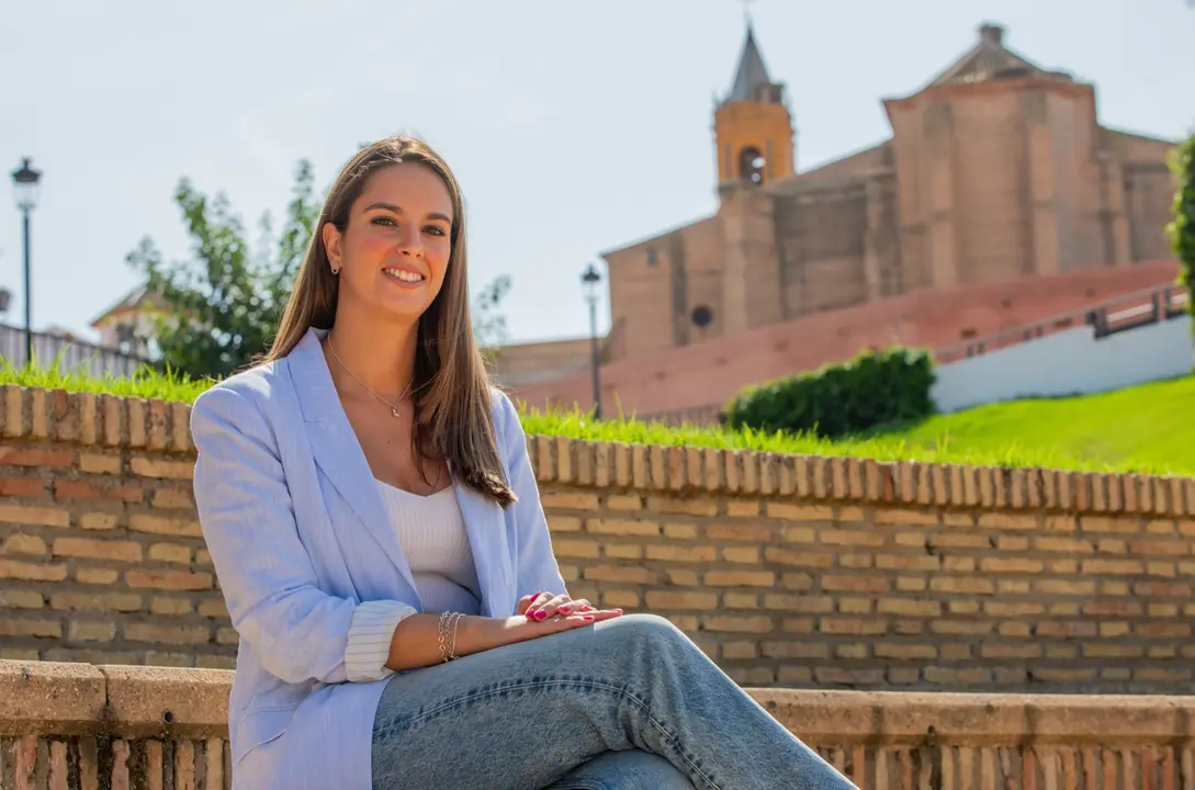 Milagros Romero con la iglesia de San Jorge al fondo