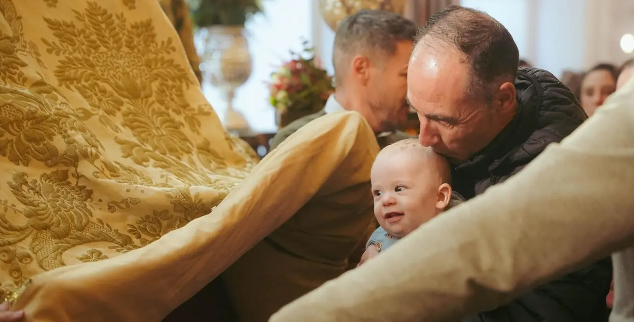 Un ni&ntilde;o sonr&iacute;e junto al manto de la Virgen del Roc&iacute;o