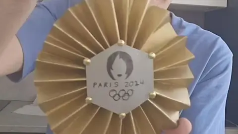 El presentador de Art Attack, Jordi Cruz, junto a la medalla de oro de arcilla que ha hecho para Carolina Mar&iacute;n. Fuente: Tik Tok Jordi Cruz