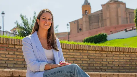 Milagros Romero con la iglesia de San Jorge al fondo