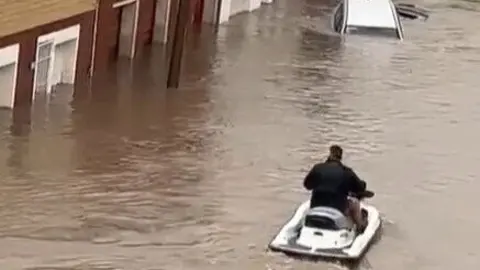 Un hombre saca su moto de agua para rescatar a los vecinos. Fuente: TikTok de rosario3.com