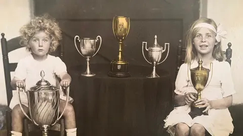 Fotograf&iacute;a tomada en su casa de Riotinto, la actual Old Engand House. Poppy, a la izquierda, sujeta la Copa del Rey de Huelva ganada por su padre en el a&ntilde;o 1921. A la derecha su hermana Hester. Imagen facilitada por la familia