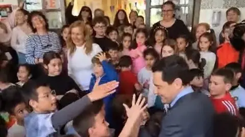 Juanma Moreno saludando a los ni&ntilde;os