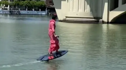 Flamenca en tabla de surf de camino a la Feria de Sevilla. Fuente: Tiktok kevinnnn221