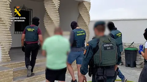 Agentes con uno de los detenidos en el nuevo golpe al narcotr&aacute;fico