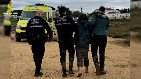 Agentes de la guardia civil y de la polic&iacute;a local de Cartaya con la mujer rescatada. Fuente: Guardia Civil