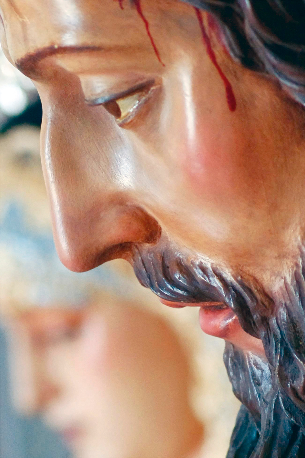 Primer plano del rostro del Cautivo de San Juan del Puerto. Al fondo el de la Virgen de la Esperanza.