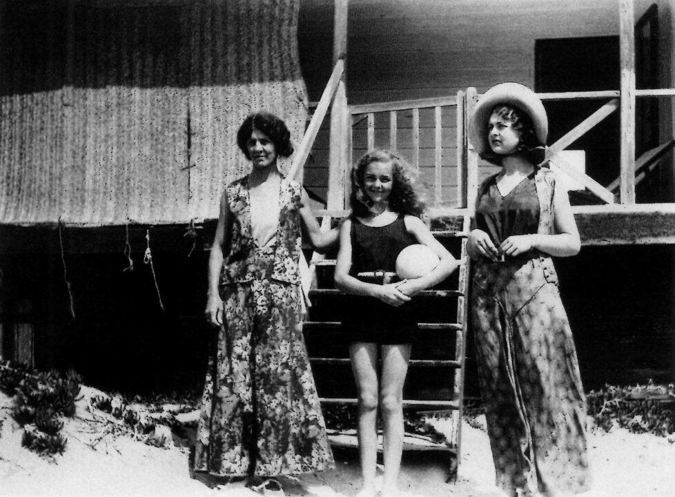 Fotografía tomada a las puertas de uno de los palafitos de Punta Umbría alrededor de 1930 o1931. Poppy en el centro con una pelota, a su derecha su madre Alice, a su izquierda su hermana Hester.