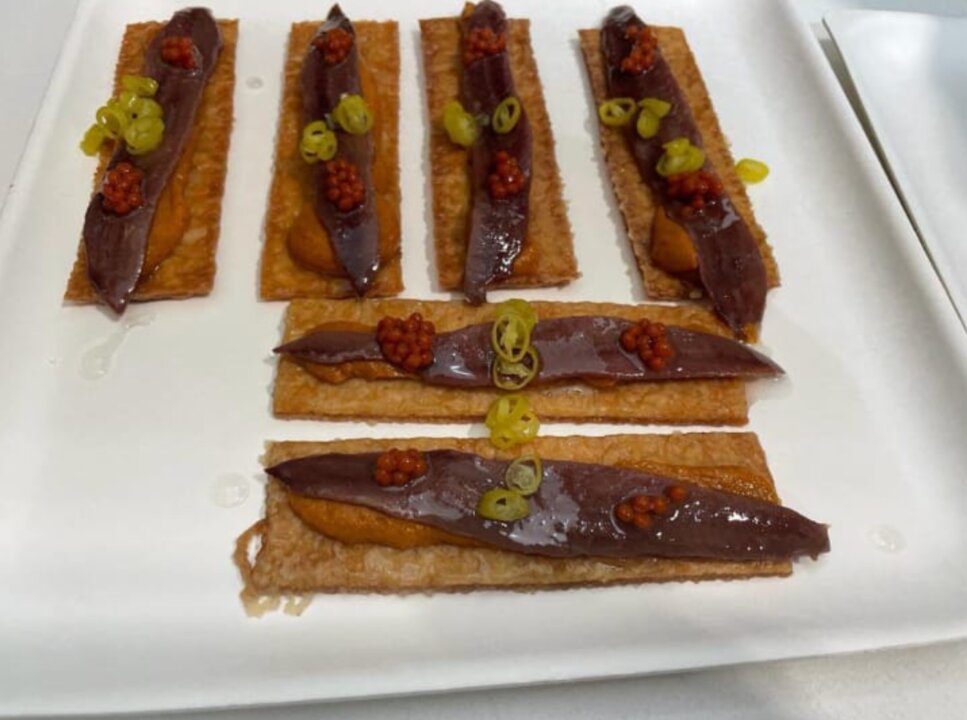 Anchoa sobre hojaldre caramelizado y emulsión de tomate. Isla Bacuta