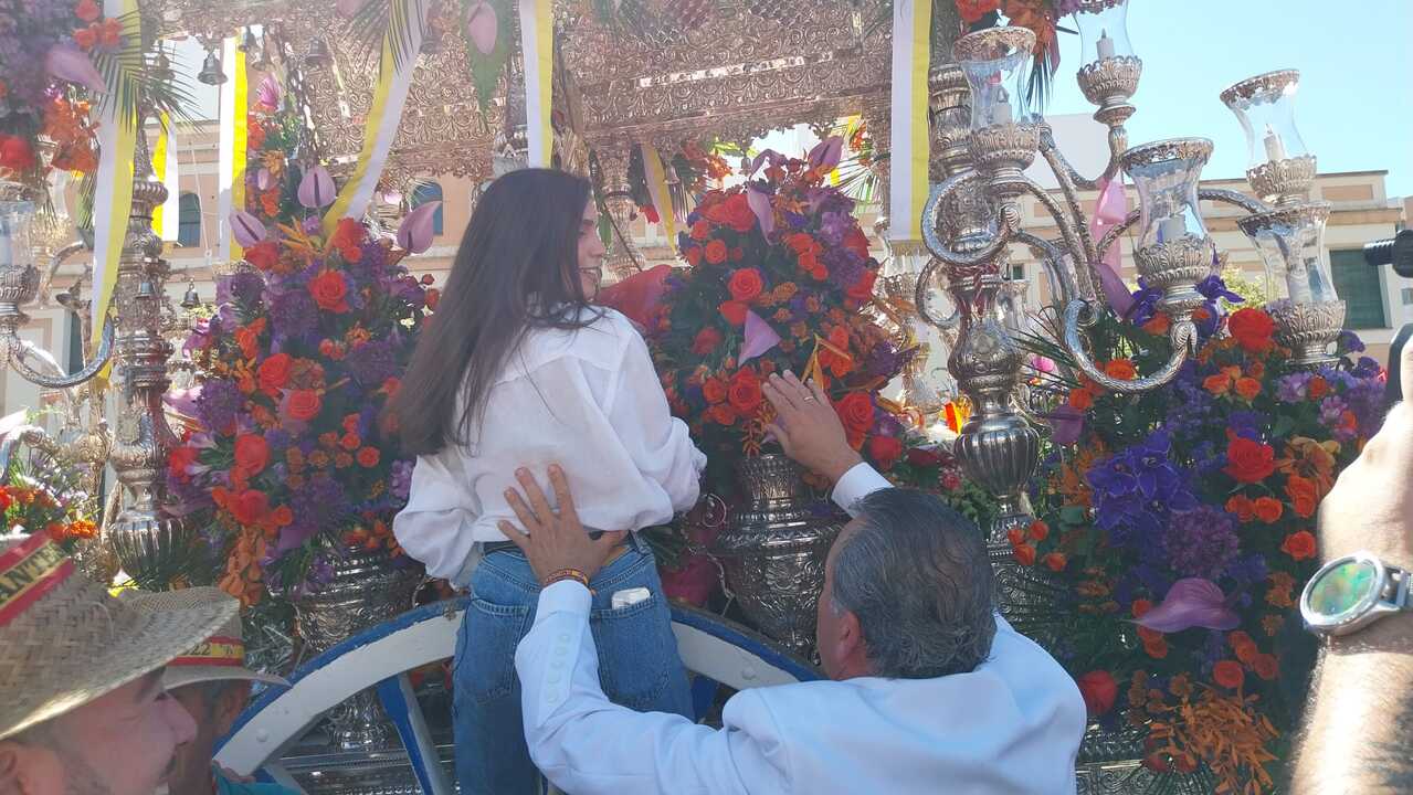 Miriam entrega un ramo de flores a la Hermandad de Emigrantes en nombre del Grupo Azahara