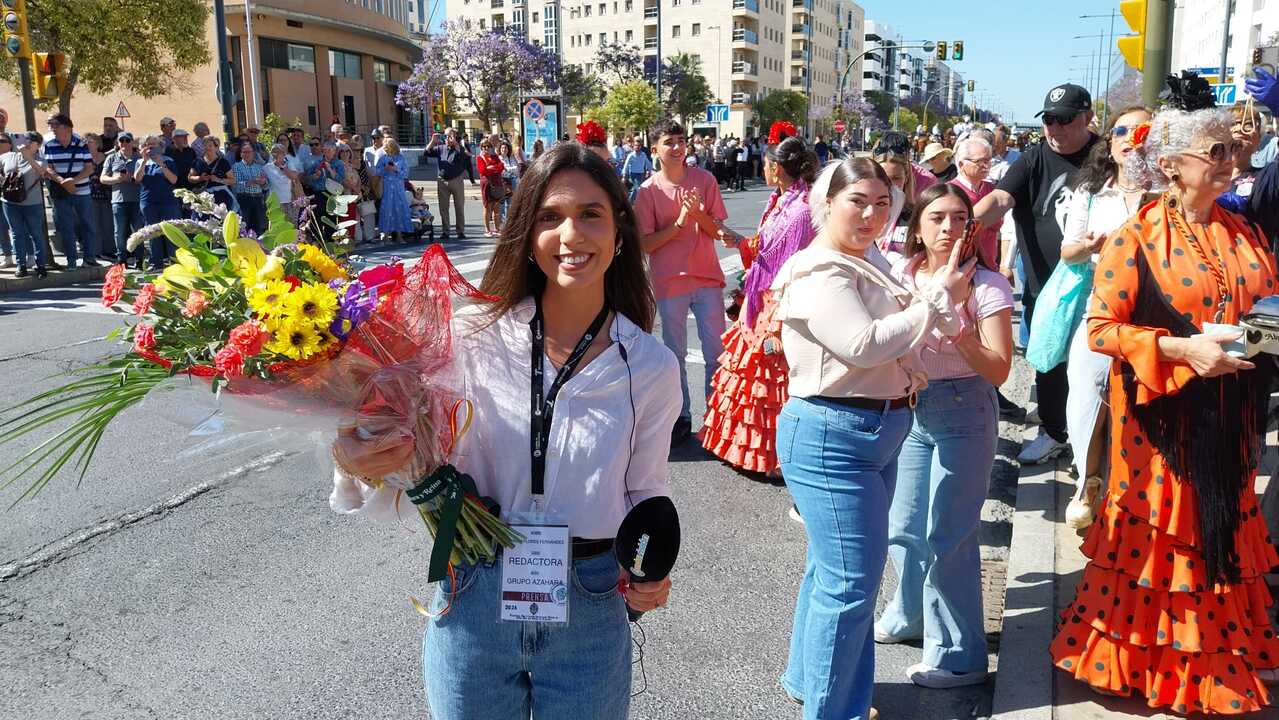 Miriam entrega un ramo de flores a la Hermandad de Emigrantes en nombre del Grupo Azahara